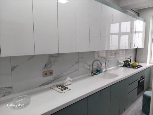 uma cozinha com armários brancos e um lavatório em Luxury Guest House em Sumqayıt