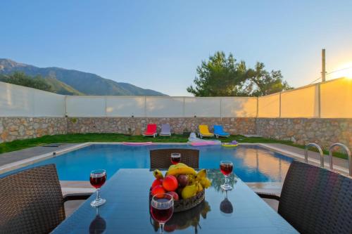 - une table avec un bol de fruits à côté de la piscine dans l'établissement Alternatif Villaları, à Fethiye