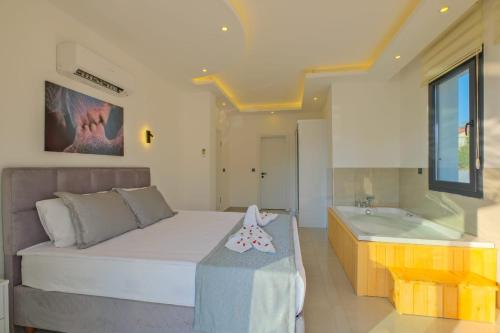 a bedroom with a bed and a bath tub at Alternatif Villaları in Fethiye