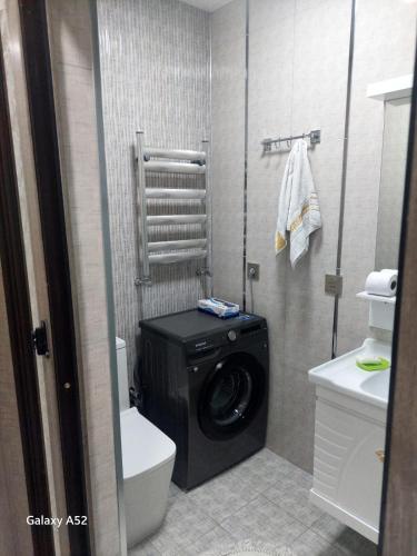a bathroom with a washer and dryer in it at Luxury Guest House in Sumqayyt