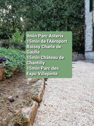 un cartel en un jardín con palabras en él en Résidence du Houx - 4 (Astérix, Aéroport CDG, Chantilly, Parc expos...) en Survilliers