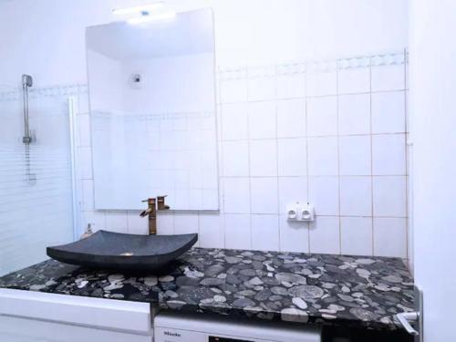 een badkamer met een zwart bad op een aanrecht bij Pretty and neat bedroom in my cosy appartment. in Puteaux