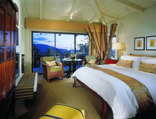 a hotel room with a bed and a large window at Tradewinds Carmel in Carmel