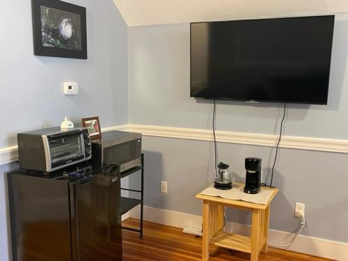 a living room with a tv and a microwave and a table at Comfortable loft with private bathroom in Boston