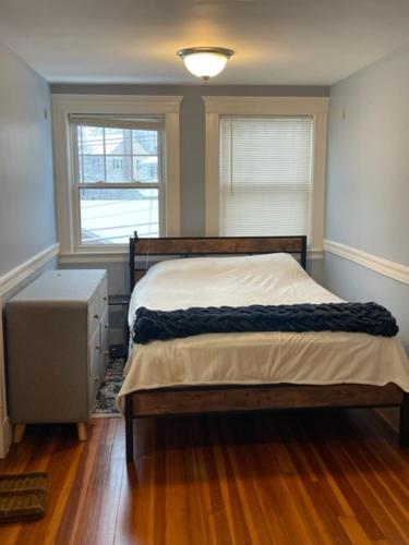a bedroom with a bed and two windows at Comfortable loft with private bathroom in Boston