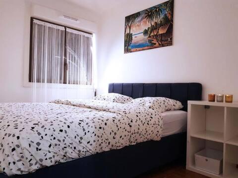 een slaapkamer met een zwart-wit bed en een raam bij Pretty and neat bedroom in my cosy appartment. in Puteaux
