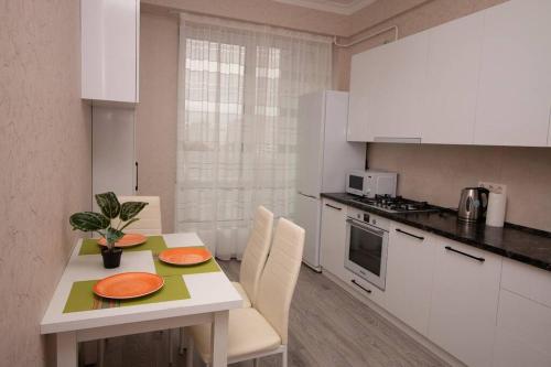 een keuken met een tafel met oranje platen erop bij Elegance 1BD apartment with living room in Chişinău