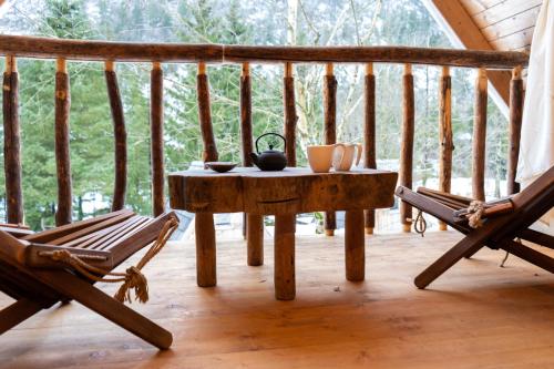 a wooden table on a porch with two chairs at Camp Korita in Soča