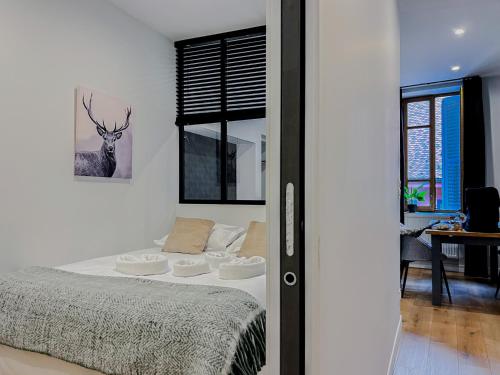 a bedroom with a bed with a deer picture on the wall at Balneo village vieille ville in Annecy
