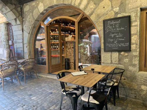 a restaurant with wooden tables and chairs in front of a store at Balneo village vieille ville in Annecy