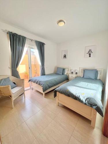 1 dormitorio con 2 camas y 1 silla en Newly Refurbished Apartment, en Cuevas del Almanzora