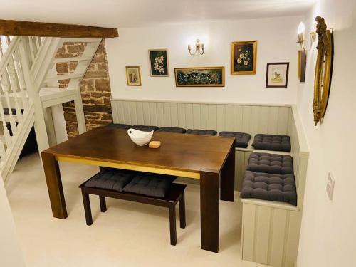 comedor con mesa de madera y sillas en The Owl House Cottage, en Welsh Newton Common