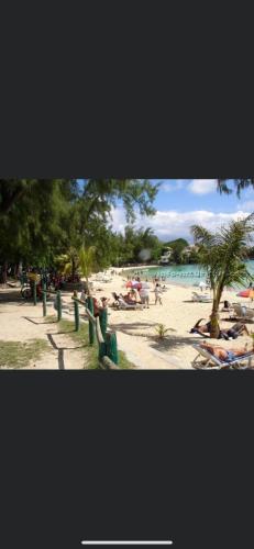 a group of people on a beach near the water at Baleau Villas Studio in Pereybere