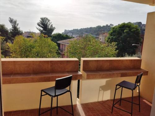 - deux chaises assises sur un balcon avec vue dans l'établissement Studio entièrement rénové coté plage avec garage, à Roquebrune-Cap-Martin