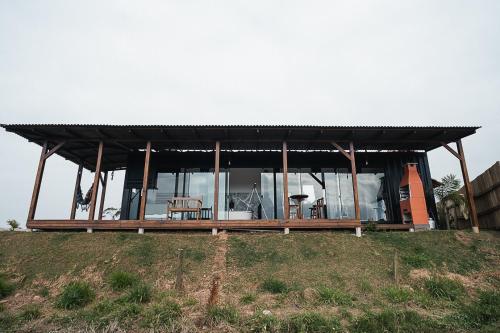 a house with a black roof on top of a hill at CASA DE VIDRO EM MEIO A NATUREZA - Conteiner Lua in Piçarras