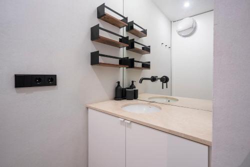 a bathroom with a sink and a mirror at La Palma Barceloneta Penthouse Apartment with Roof Top Terrace in Barcelona