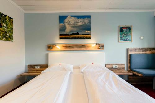 a bedroom with a bed and a blue chair at Landhotel GrünWies -Bonsai-Wellness Garni in Lohberg