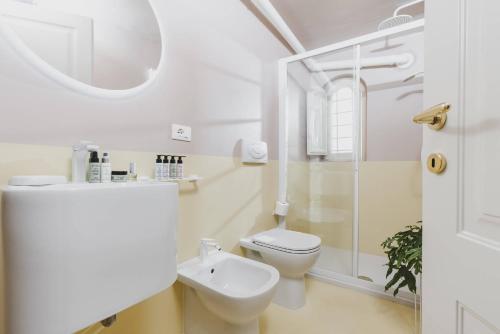 Casa Horti Suites في لاكويلا: حمام ابيض مع مرحاض ومغسلة