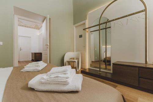 a bathroom with two beds and a large mirror at Casa Horti Suites in LʼAquila