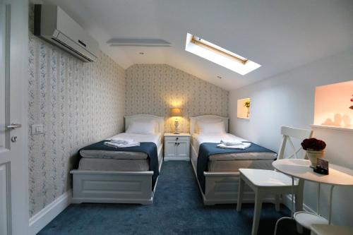 Un pat sau paturi într-o cameră la Hotel Les Jardins Carol