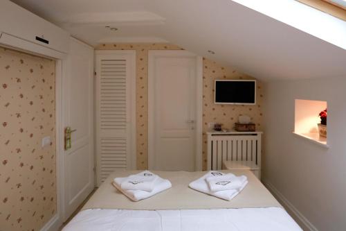a bedroom with two white towels on a bed at Hotel Les Jardins Carol in Bucharest