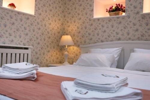 a bedroom with a white bed with towels on it at Hotel Les Jardins Carol in Bucharest