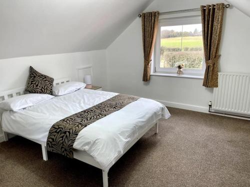 a bedroom with a large bed and a window at 5-Bedroom Cottage in Healing, Grimsby in Healing