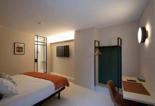 Schlafzimmer mit einem Bett, einem Schreibtisch und einem Fenster in der Unterkunft Mythic Valencia in Valencia