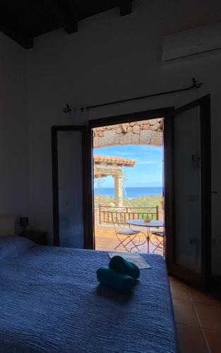 a bedroom with a bed and a view of the ocean at Villa Acchiappasogni in Porto San Paolo
