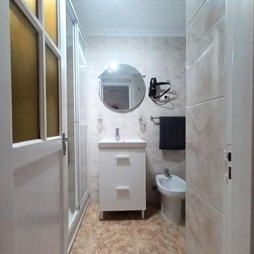 a bathroom with a sink and a mirror and a toilet at Beachfront apartment Don Paco Patalavaca in Patalavaca