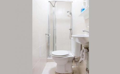uma casa de banho branca com um WC e um chuveiro em Litsa's Central Studios em Londres
