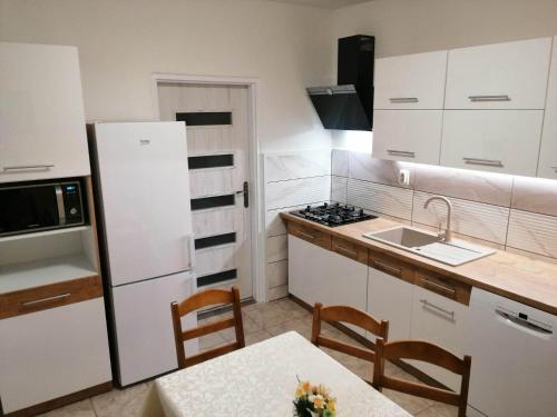 a kitchen with a white refrigerator and a table at Apartmán West in Poprad