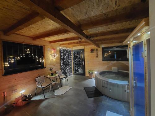 ein Bad mit einer Badewanne, einem Tisch und Stühlen in der Unterkunft Rural Holiday House Tinna in Biškupec Zelinski