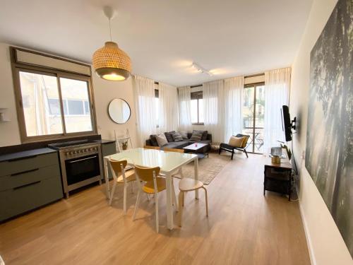 a kitchen and living room with a table and chairs at Sea Suites in Tel Aviv