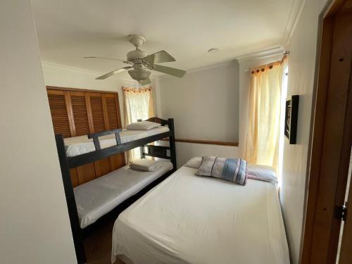 カルタヘナ・デ・インディアスにあるApartamento familiar.のベッドルーム1室(二段ベッド2台、シーリングファン付)