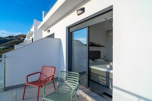 two chairs and a bed on the balcony of a house at Terrazas de Ladera Duplex 7 Casasol in Nerja