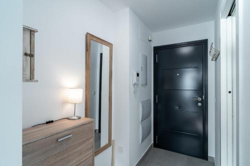 a hallway with a black door and a mirror at Terrazas de Ladera Duplex 7 Casasol in Nerja