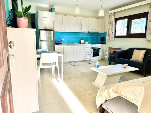 a kitchen and living room with a couch and a table at Sermilie Beach Houses in Psakoudia