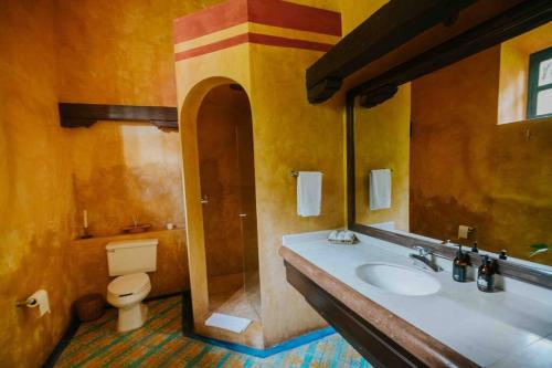 a bathroom with a sink and a toilet and a mirror at Hacienda extraordinaria, jardines preciosos y pirámides 