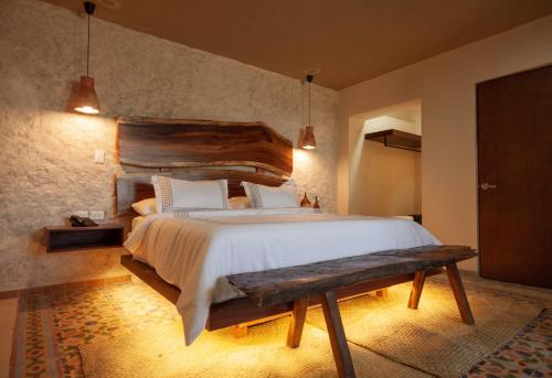 - une chambre avec un grand lit et un banc en bois dans l'établissement Hotel Scappata, à Progreso