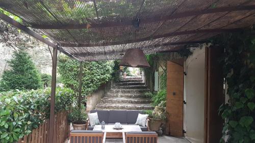 a patio with a table and a pergola and stairs at Bastide en Provence in Auriol