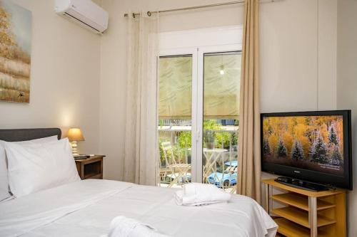 una camera da letto con un letto, una TV e una finestra di Fully renovated flat close to Uni & hospitals ad Atene