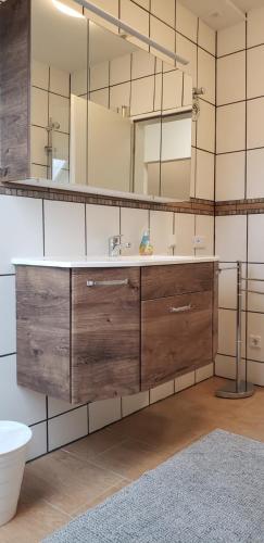 a bathroom with a sink and a large mirror at Ferienwohnung in Stelle bei Familie Thieshen in Stelle