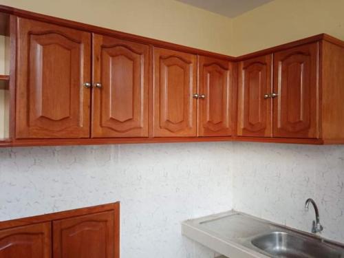 a kitchen with wooden cabinets and a sink at Apartamentos en Huanchaco in Huanchaco