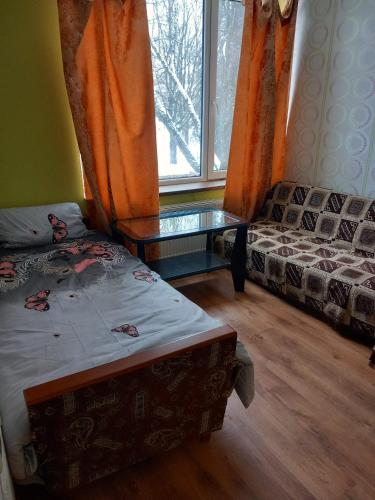 Zimmer mit einem Bett, einem Sofa und einem Fenster in der Unterkunft Balvu Centrs 2 Partizanu iela 10 in Balvi