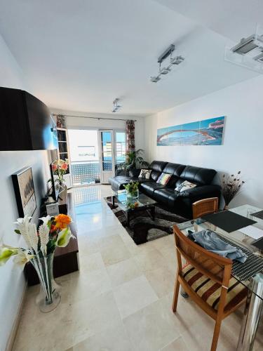 una sala de estar con un sofá y una mesa en Elena is a comfortable and well located flat, en Las Palmas de Gran Canaria