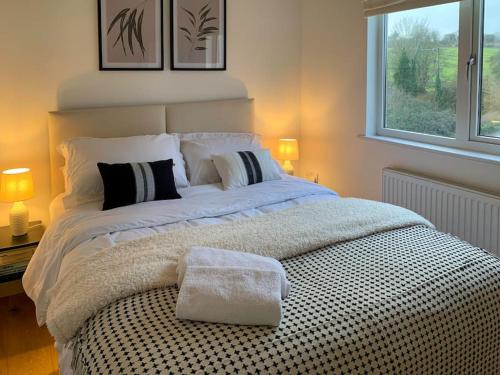 Un dormitorio con una cama grande y una ventana en South Downs View en West Meon