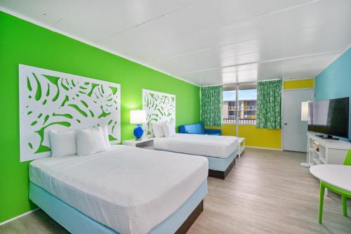 Cette chambre comprend 2 lits et une télévision. dans l'établissement Kokomo Suites, à Ocean City