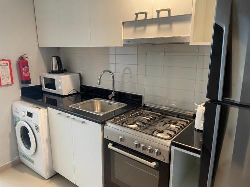 a small kitchen with a stove and a sink at Incredible Ocean View Studio Aprtment in Al Marjan Island in Ras al Khaimah