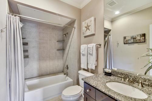 a bathroom with a sink and a tub and a toilet at Dawn 824-Sea n Swim in Galveston